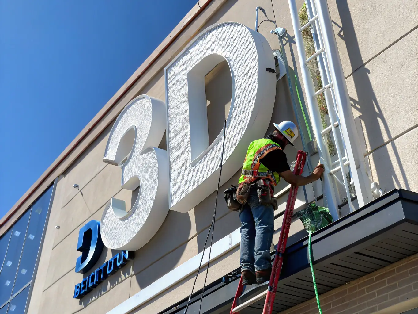 A professional technician installing an LED sign on a building facade, ensuring precise alignment and secure mounting.
